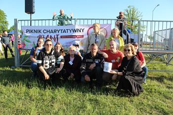Zdjęcie grupowe Uczestników oraz Kadry ŚDS w na tle baneru z napisem Piknik Charytatywny dla Ani