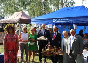 Pani Kierownik ŚDS w Gryfinie wraz z Burmistrzem Gryfina pozują do zdjęcia grupowego na tle namiotów