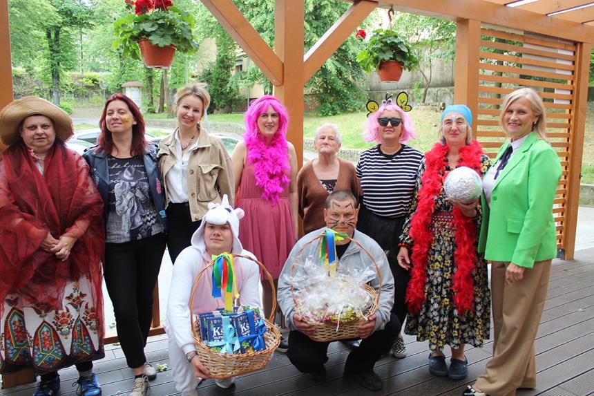1.Pani Kierownik ŚDS w Gryfinie w raz z kadrą oraz uczestnikami w kolorowych przebraniach stojący na tarasie D