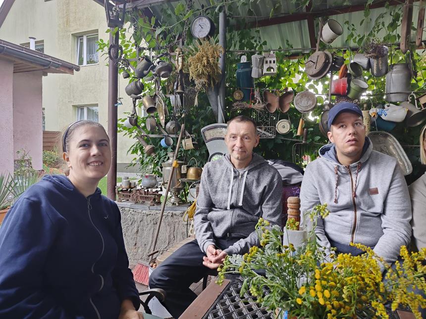 1.Uczestnicy siedzący przy stole na tle ściany z zabytkami D