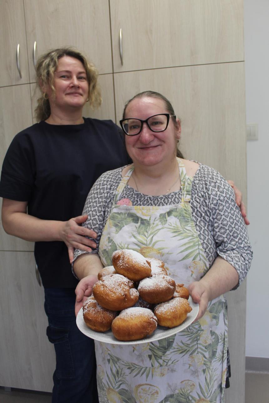 1.Uczestniczka oraz terapeutka trzymający tależ pełen pączków D