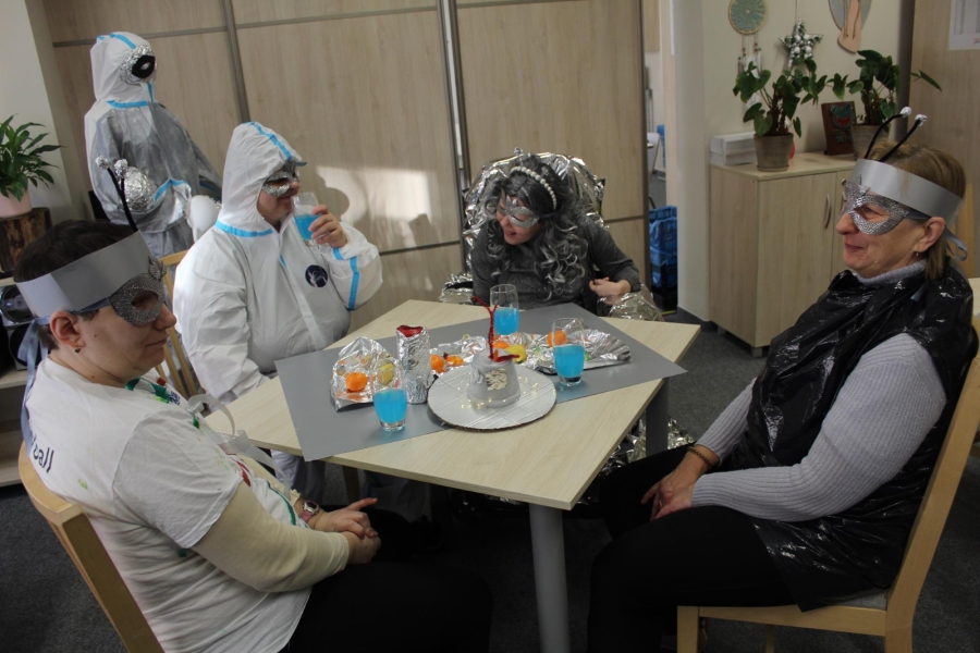 2 – Uczestnicy w strojach karnawałowych siedzący przy stole.