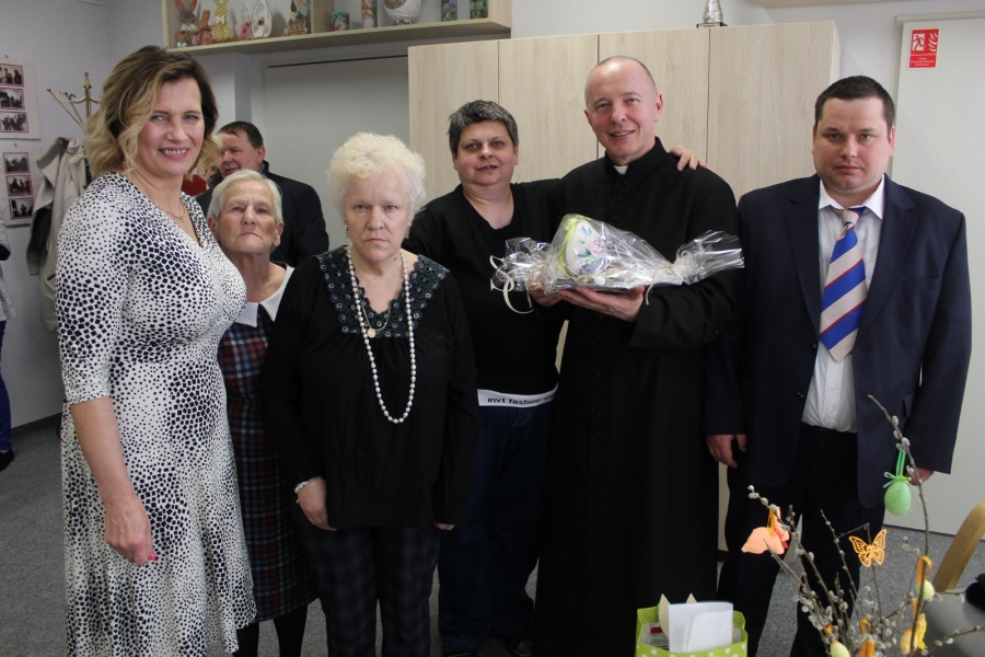 4 – Kierownik ŚDS w Gryfinie wraz z Uczestnikami i księdzem pozuje do zdjęcia grupowego.