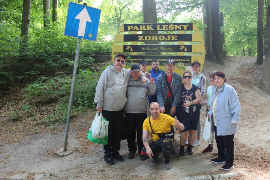 Grupa Uczestników pozuje do zdjęcia na tle tablicy Park Leśny Zdroje.