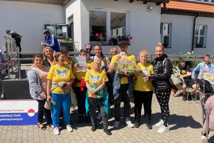 Grupa Uczestników wraz z terapeutami pozuje do zdjęcia grupowego.