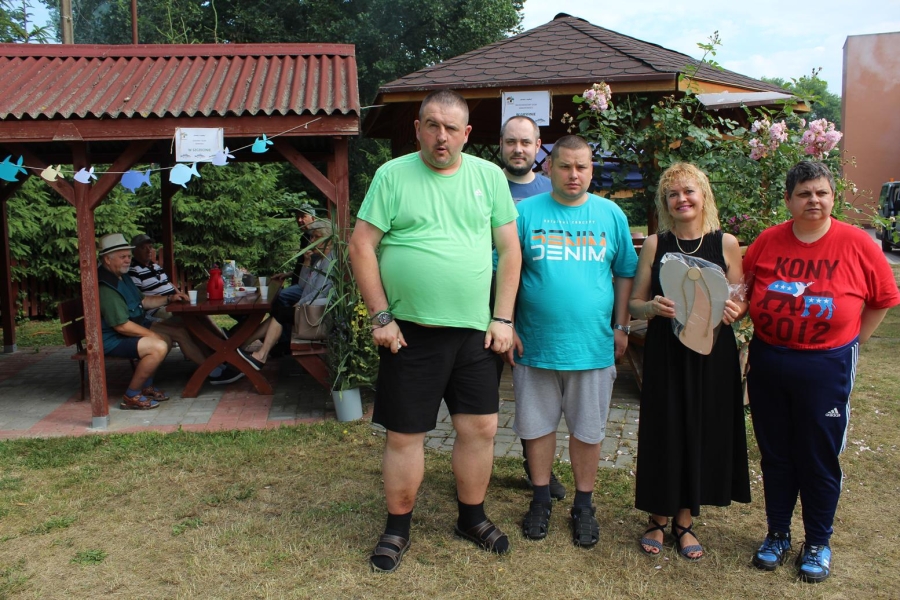 Grupa uczestników wręcza rękodzieło Pani Kierownik DPS w Dębcach. 