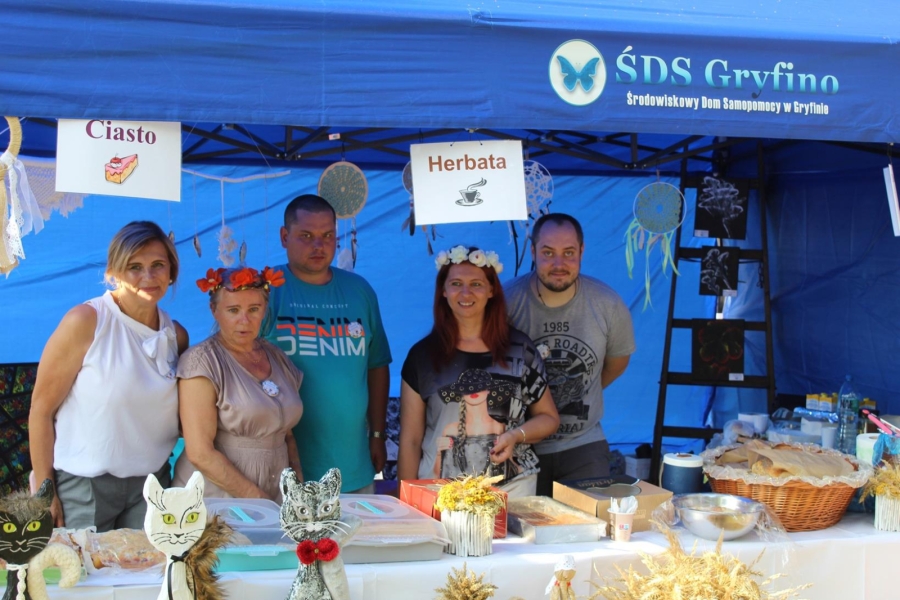 2. Kierownik ŚDS w Gryfinie, terapeuci oraz Uczestnicy pozują do zdjęcia przy stoisku. 