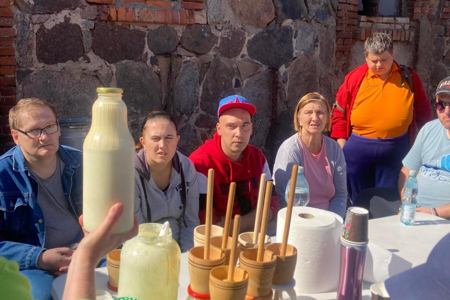 1. Gospodarz pokazujący Uczestnikom butelkę wyrobionego masła.