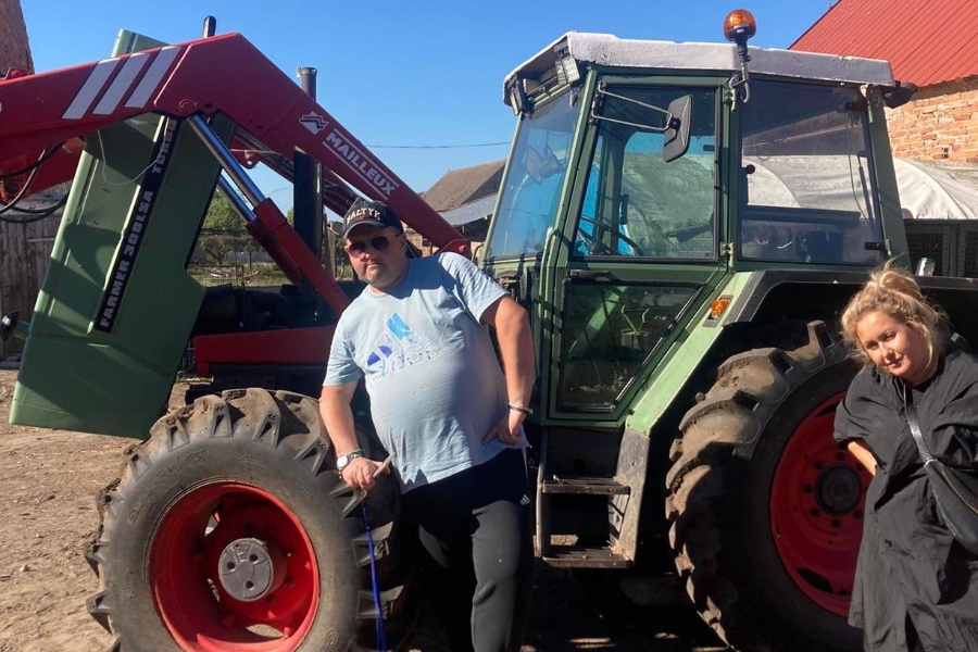 7. Uczestnik wraz z terapeutką pozuje do zdjęcia przy traktorze.