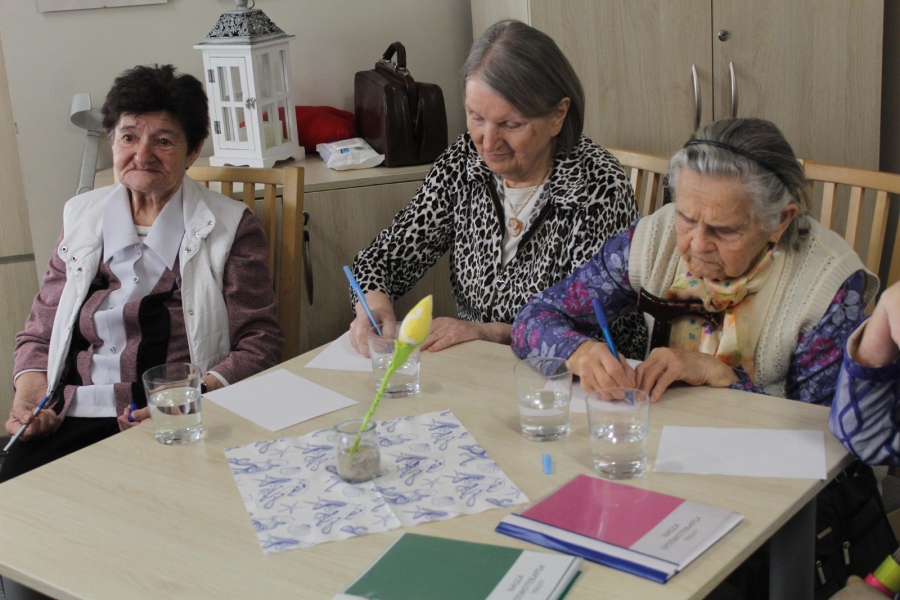 2.Trzy Panie z Dziennego Domu Seniora+ przy stole, piszą na kartkach