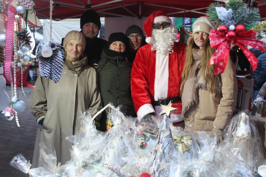 1.Uczestnicy oraz kadra ŚDS w Gryfinie pozują do zdjęcia ze Świętym Mikołajem na tle rękodzieła