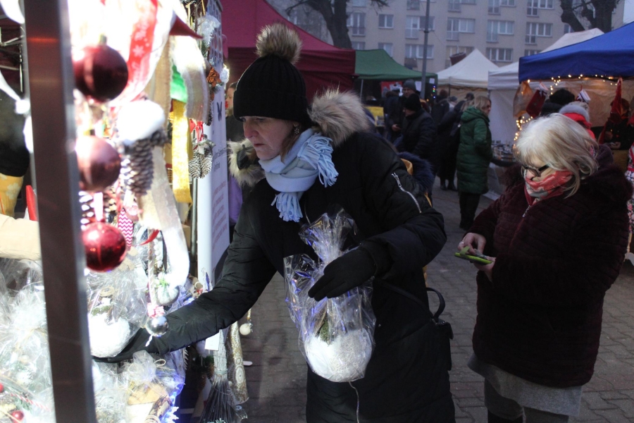 2.Pani w czarnej kurtce oglądająca prace znajdujące się na stoisku ŚDS w Gryfinie