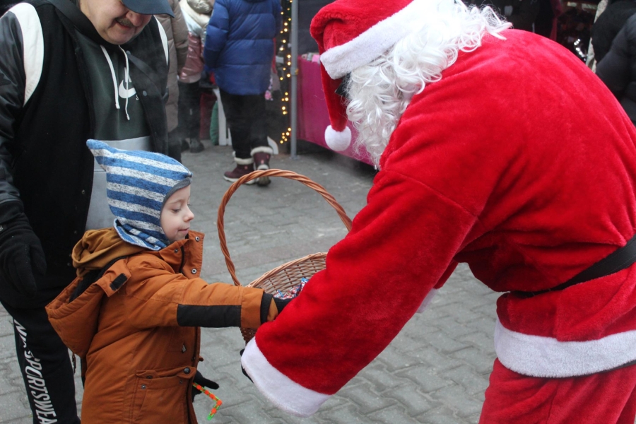 3.Święty Mikołaj częstujący dziecko cukierkami z kosza wiklinowego
