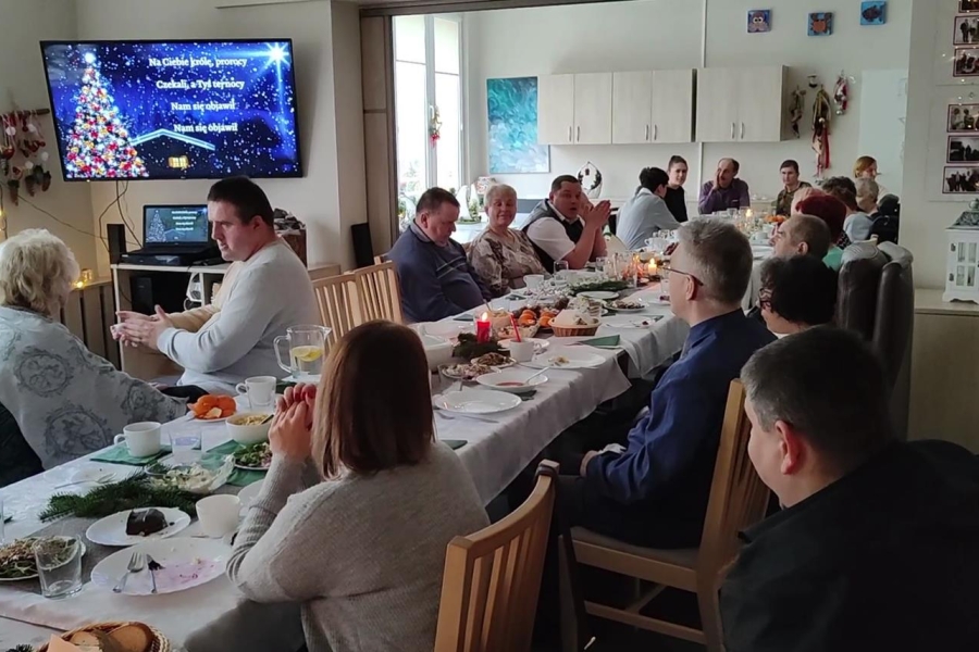 3.Uczestnicy oraz ich rodziny śpiewający kolędy przy stole Wigilijnym