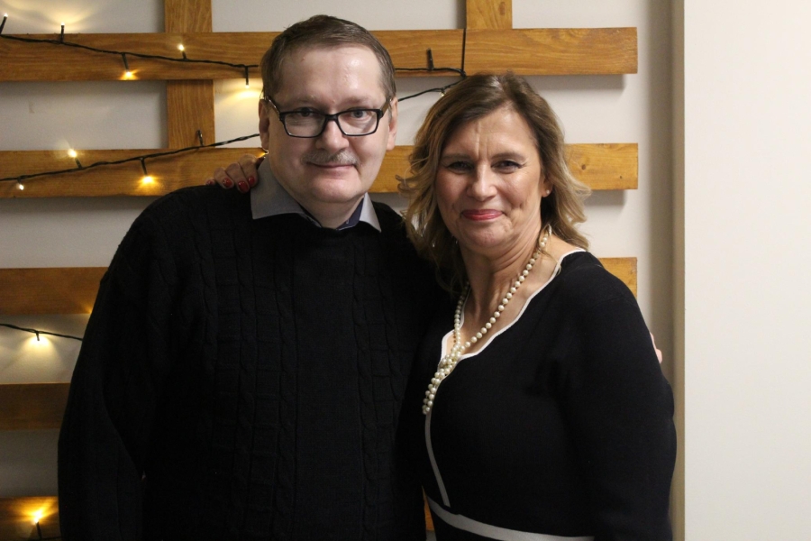 4.Uczestnik wraz z Kierownik ŚDS w Gryfinie uśmiechają się na tle lampek choinkowych