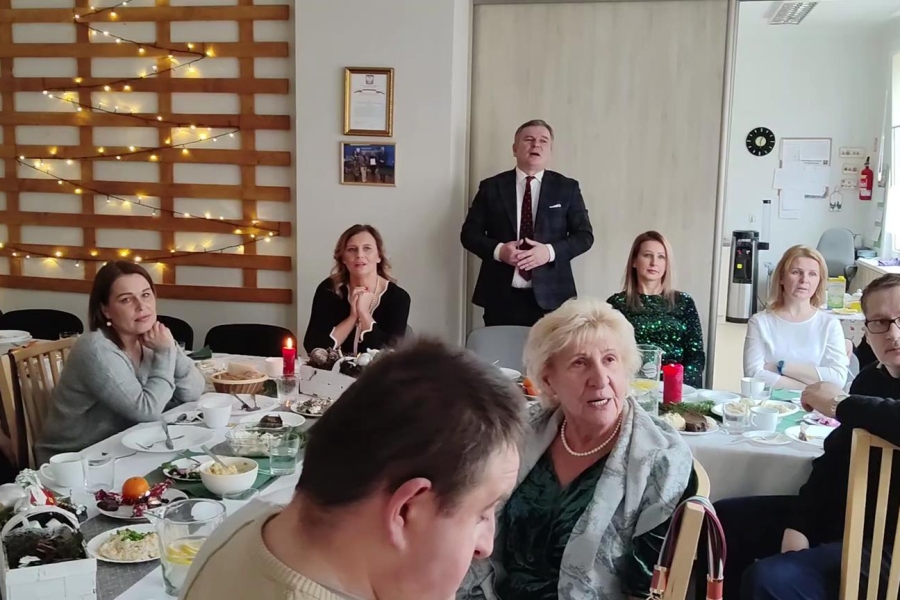 5.Zastępca Burmistrza Miasta i Gminy Gryfino, kadra, uczestnicy ŚDS w Gryfinie oraz ich rodziny śpiewający kolędy przy stole Wigilijn