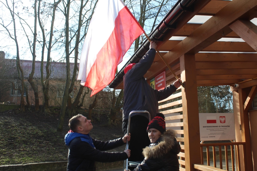2.Trójka uczestników zawieszających flagę Polski na tarasie ŚDS w Gryfinie