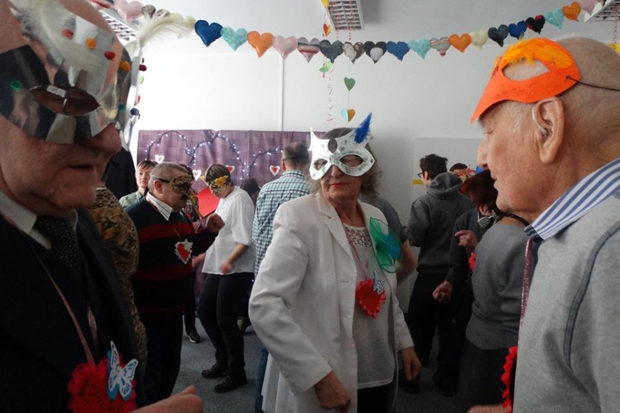 Troje seniorów na tle balu karnawałowego