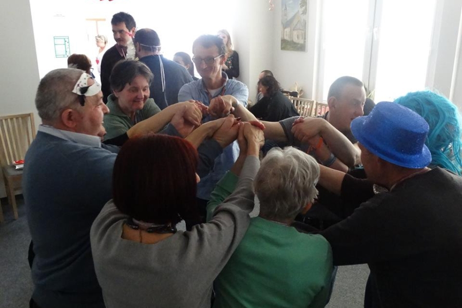 Grupa uczestników trzymających się za ręce podczas wspólnej zabawy