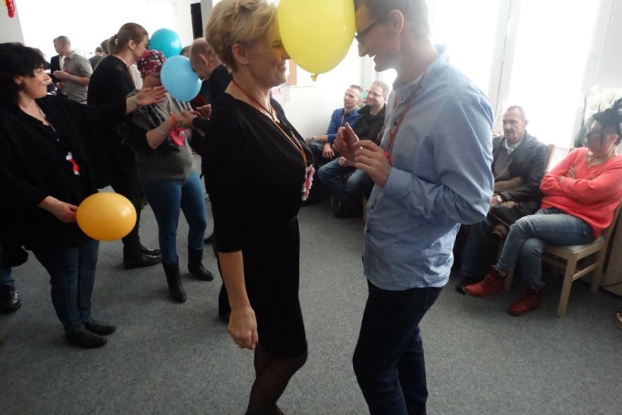 Pani Kierownik tańcząca z uczestnikiem z balonem między głowami