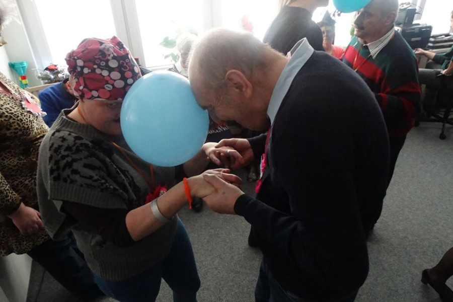 Uczestnicy tańczący z balonem między głowami