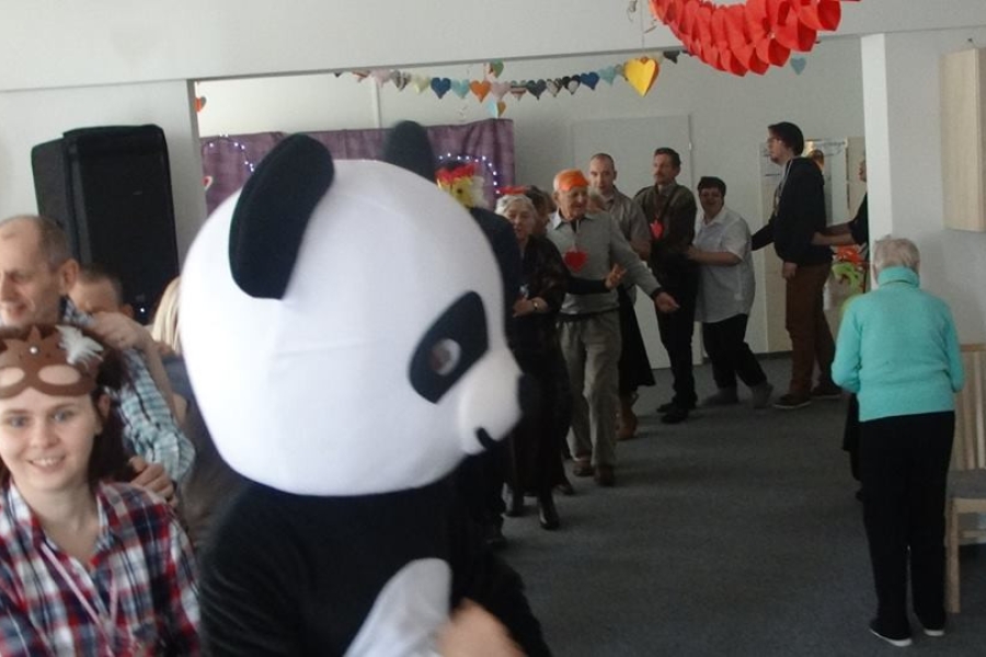 Uczestnicy podczas zabawy w pociąg na tle Pandy