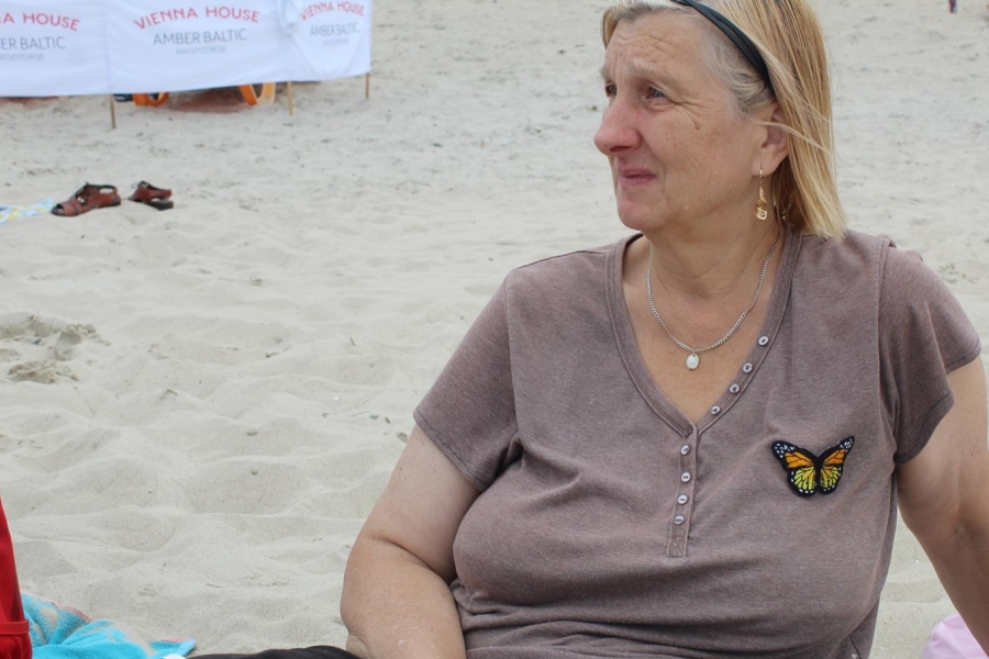 2.Uczestniczka siedząca na kocu na plaży