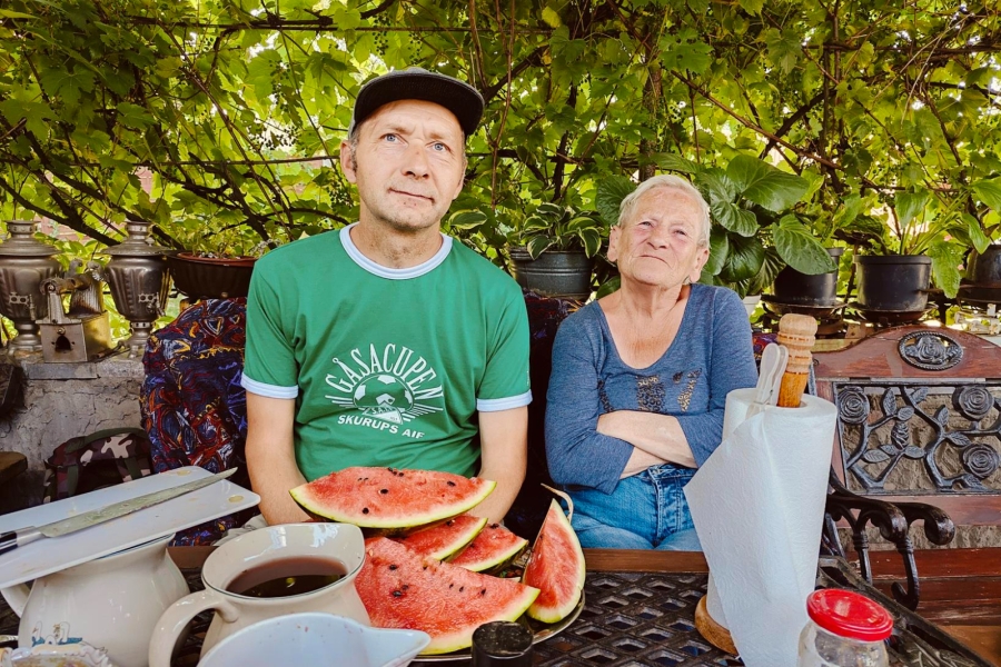 2.Uczestnk oraz uczestniczka siedzą przy stole na tle winogron