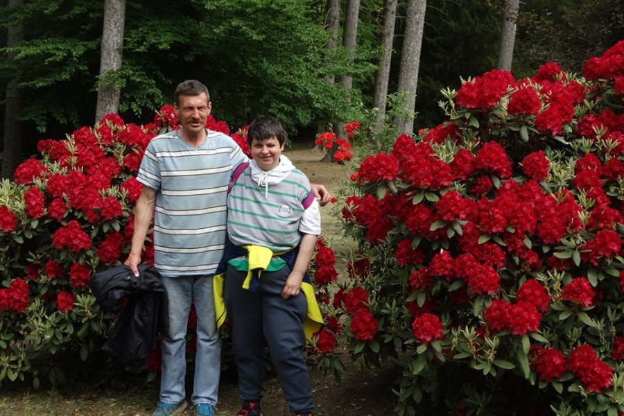 Dwoje uczestników na tle czerwonych kwiatów