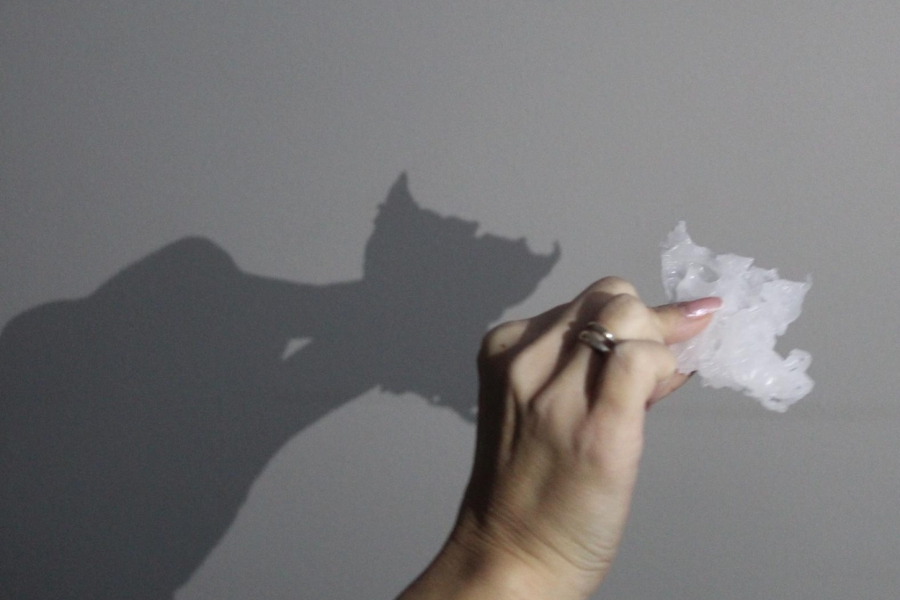 4.Dłoń trzymająca wosk rzucający cień na ścianę