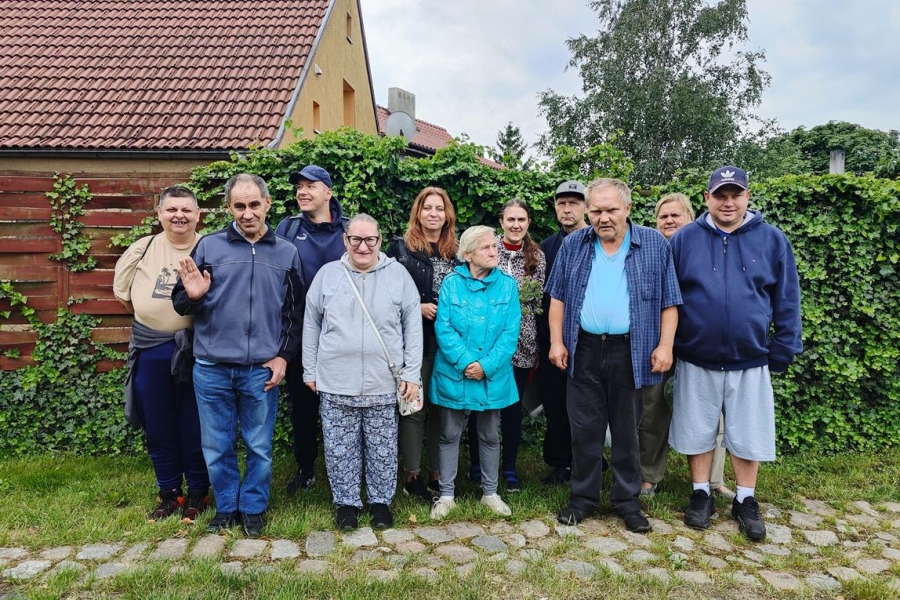 1.Gospodarze oraz uczestnicy stojący na tle żywopłotu