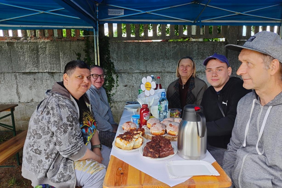 1.Uczestnicy ŚDS w Gryfinie siedzący przy stole z poczęstunkiem