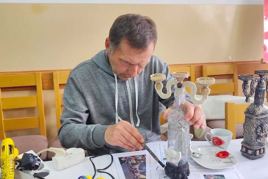 6.Uczestnik przy stole malujący świecznik