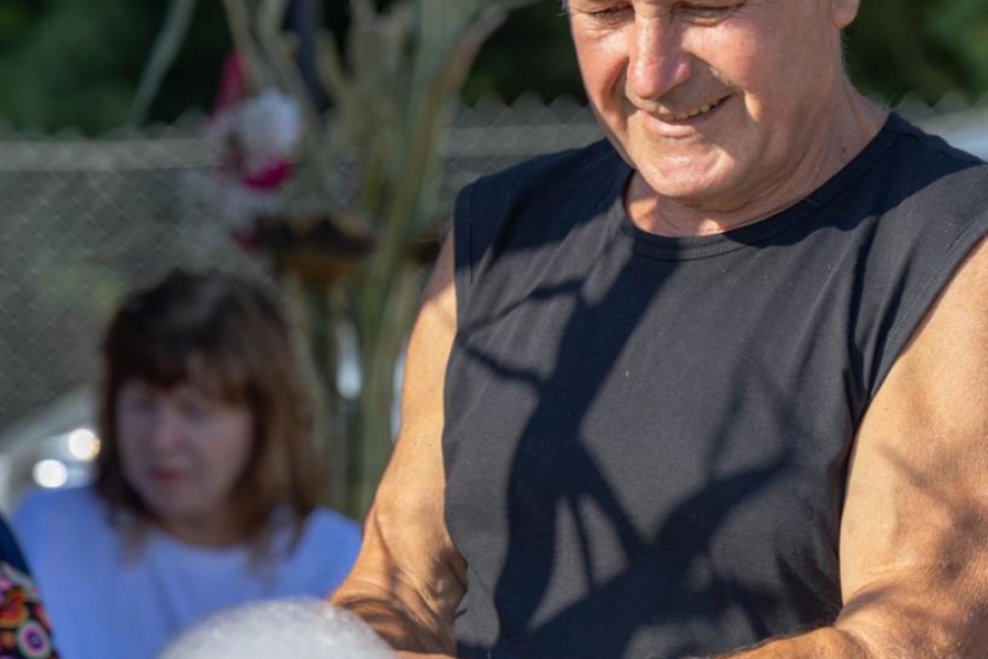 6.Uśmiechający się Pan w czarnej koszulce robiący watę cukrową