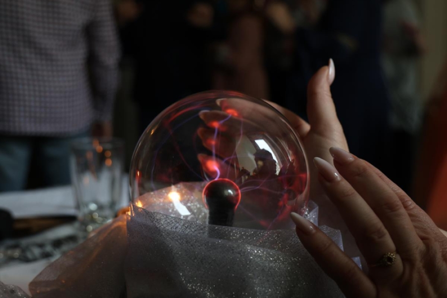 4.Dłonie nad kryształową kulą na tle bawiących się osób