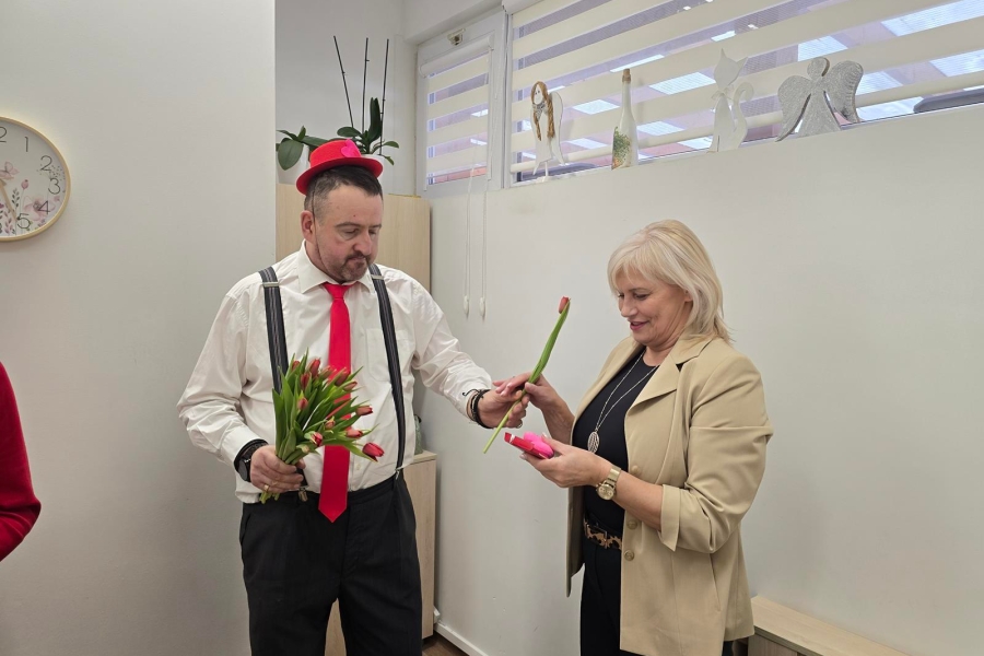 2.Uczestnik w szelkach wręczający tulipana Kierownik ŚDS 