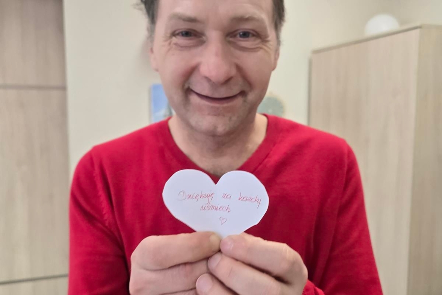 3.Uczestnik w czerwonym swetrze trzymający papierowe serce 