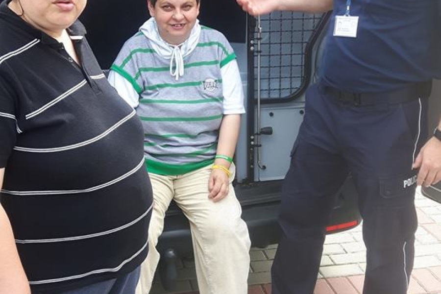Dwoje uczestniczek z policjantem przy radiowozie