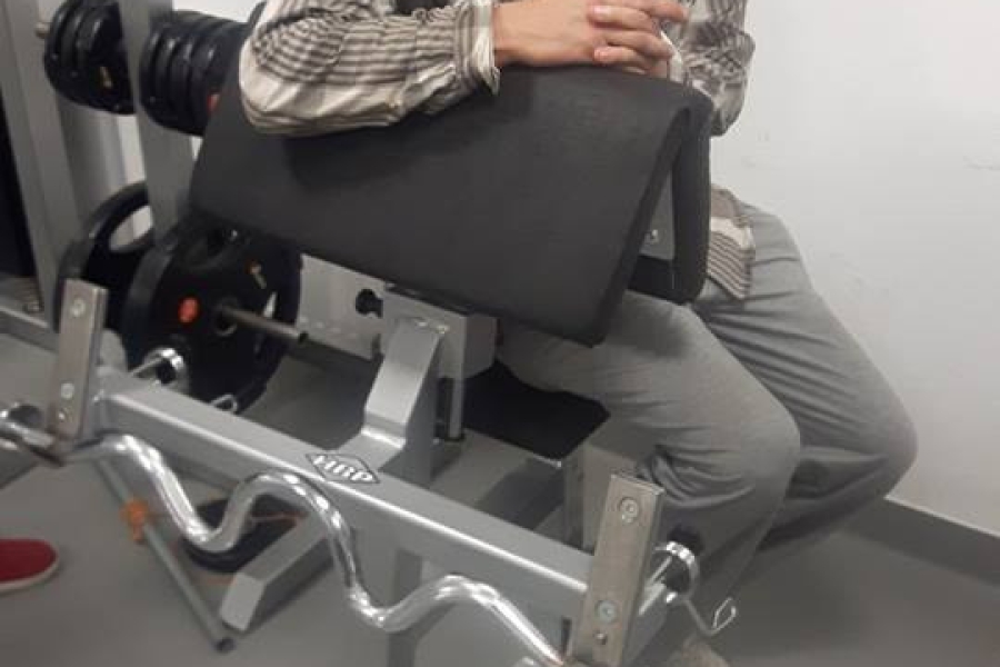 Uczestnik siedzący na ławce treningowej na policyjnej siłowni 