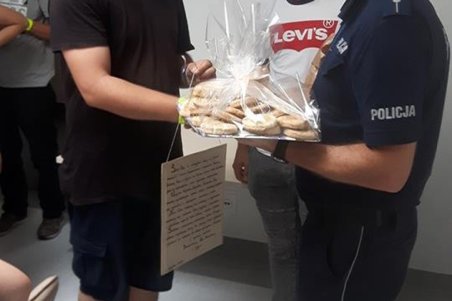 Uczestnik wręczający upominek funkcjonariuszowi policji 