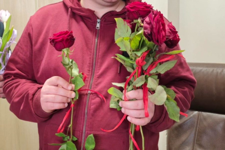 1.Uczestnik w czerwonej bluzie trzymający róże