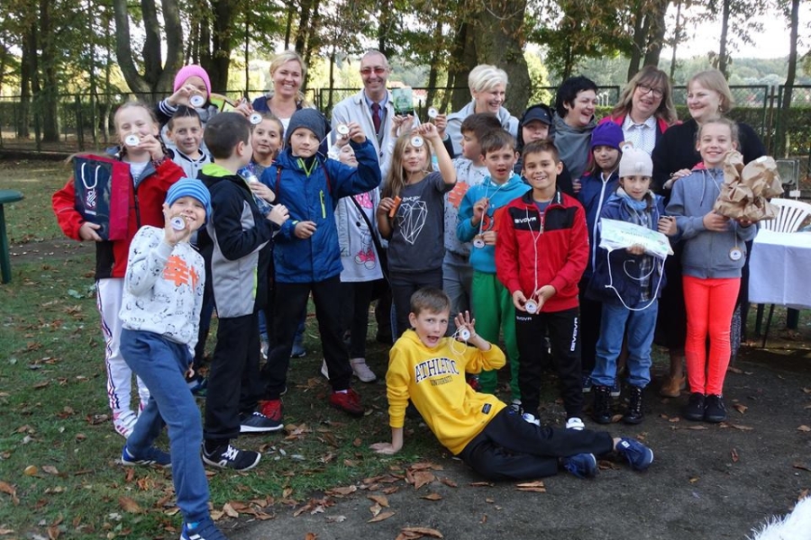 Grupa dzieci wraz z organizatorami trzymające medale