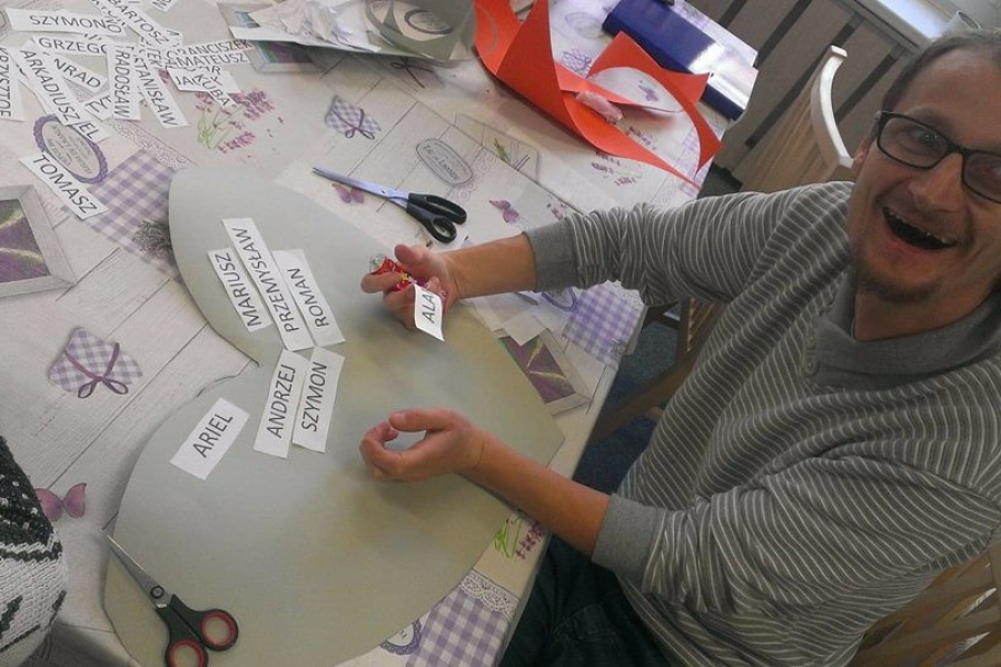 Uczestnik przyklejając imiona na serce