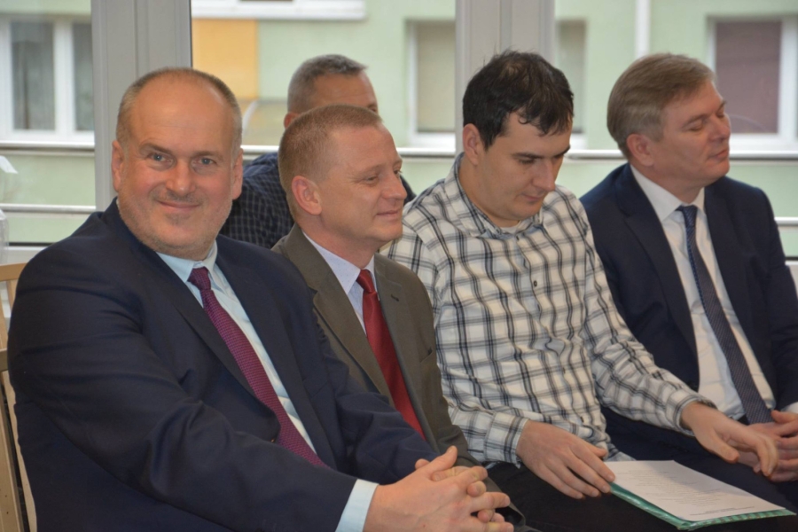 Uśmiechnięty burmistrz na tle gości