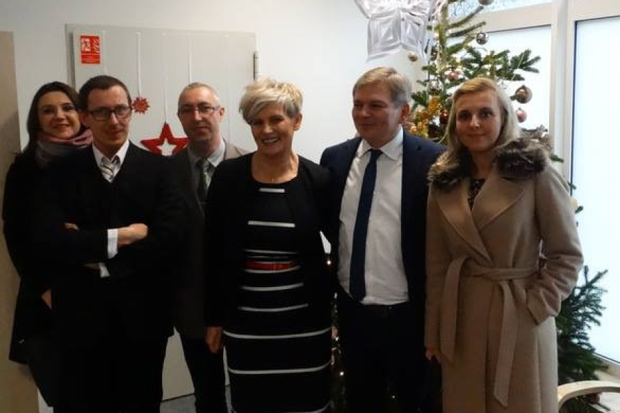 Kierownik z Burmistrzem oraz gośćmi na tle choinki