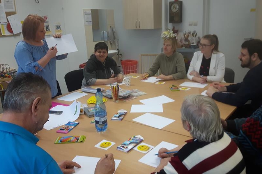 Grupa uczestników wraz z terapeutą podczas zajęć o emocjach. 