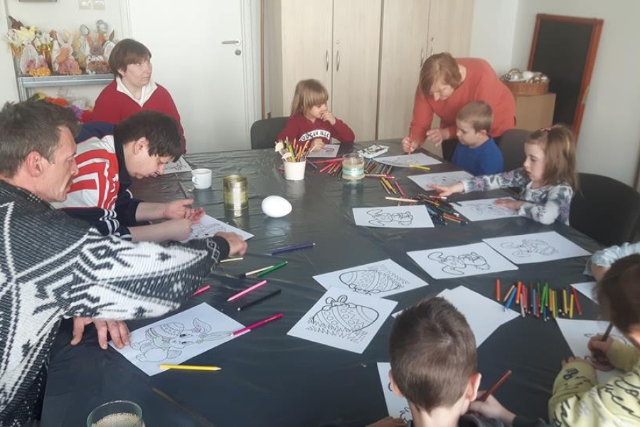 Uczestnicy wykonywający prace plastyczne wraz z dziećmi.