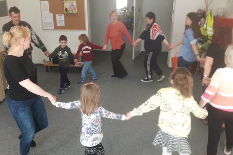 Uczestnicy wraz z dziećmi tańczący w kółku