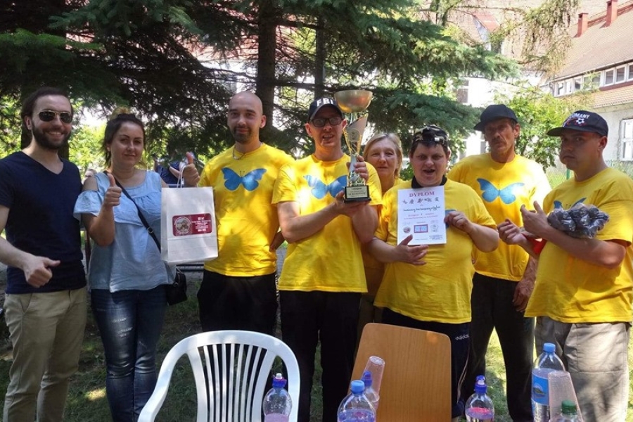 Uczestnicy wraz z terapeutami przedstawiający dyplomy , puchar oraz nagrody.