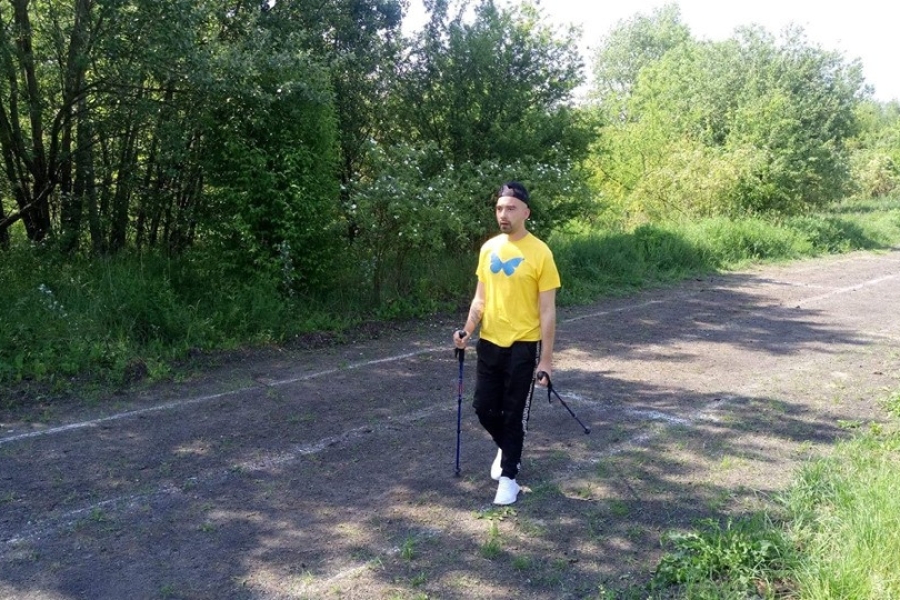 Uczestnik podczas marszu z kijami.